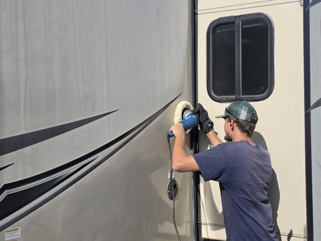 Unplug RV technician machine-buffing the gel coat on a travel trailer in Lincoln, CA